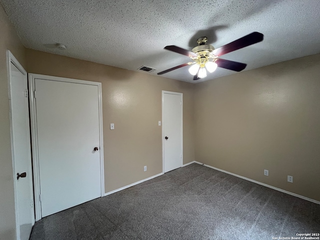 spare room featuring a textured ceiling, carpet, and ceiling fan