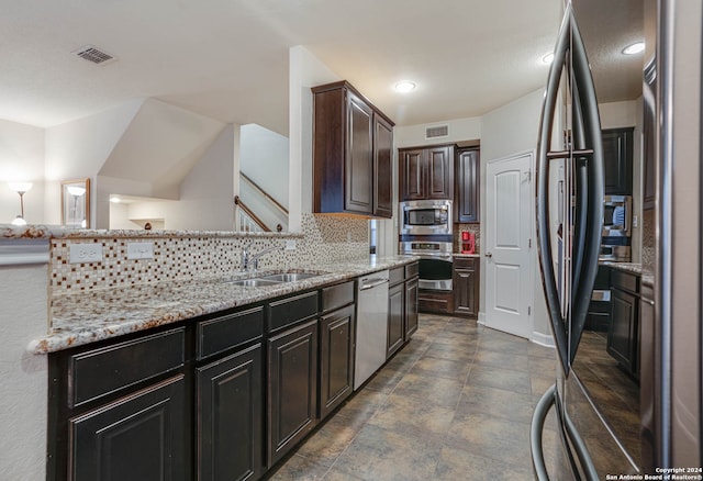 kitchen featuring dark brown cabinets, light stone counters, tasteful backsplash, sink, and stainless steel appliances