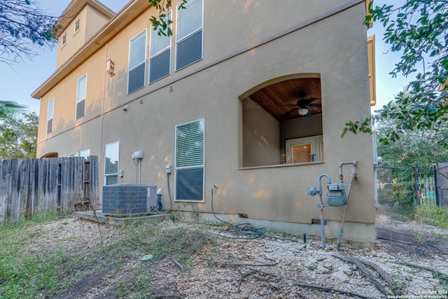 rear view of house featuring cooling unit and ceiling fan