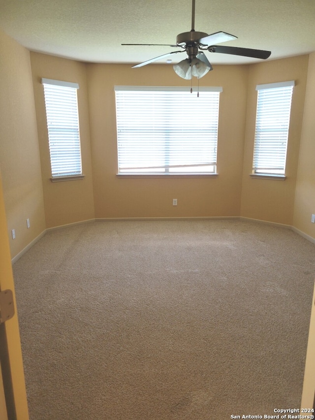 empty room with ceiling fan and carpet