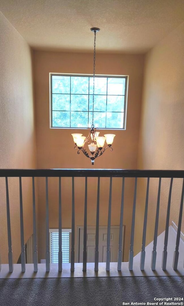 stairway with a healthy amount of sunlight and a notable chandelier