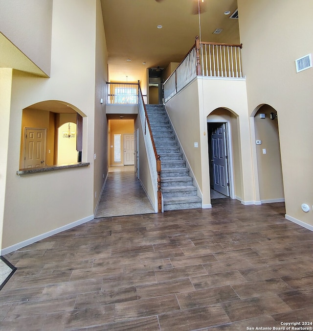 staircase featuring a towering ceiling and hardwood / wood-style flooring