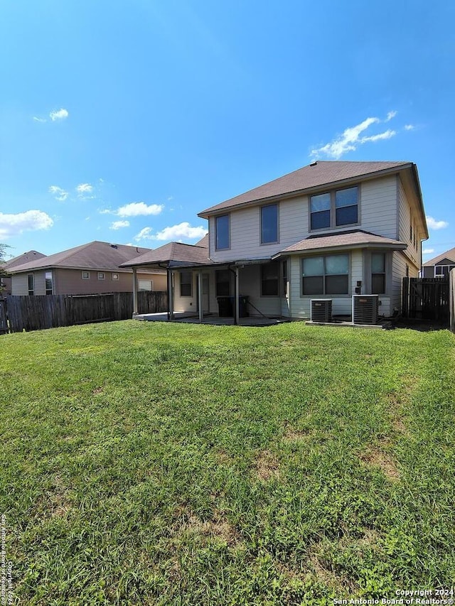 back of property featuring a yard and central air condition unit