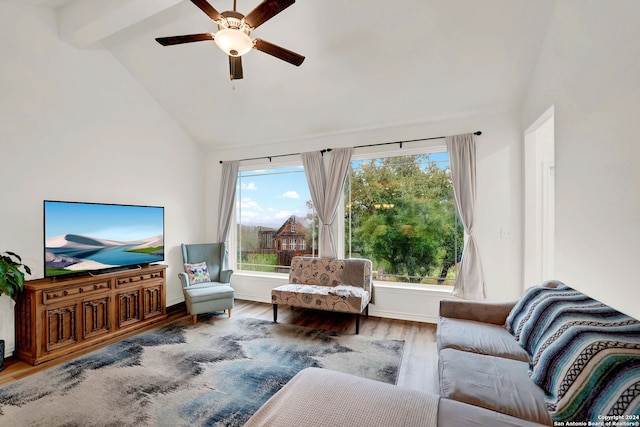 living area featuring plenty of natural light, wood finished floors, vaulted ceiling with beams, and ceiling fan