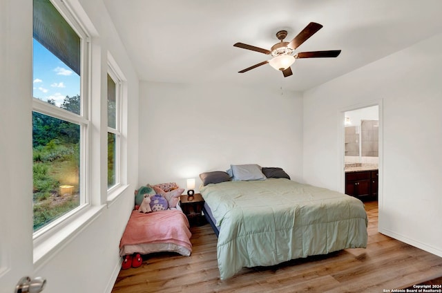 bedroom featuring baseboards, multiple windows, and light wood finished floors