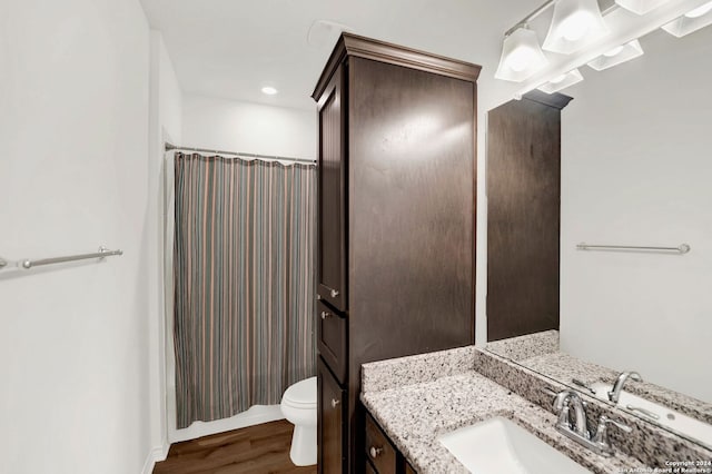 full bathroom featuring a shower with curtain, toilet, wood finished floors, and vanity