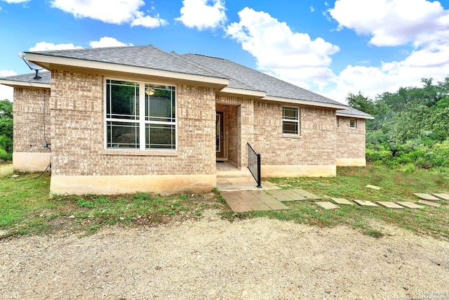 view of front of home with brick siding and a shingled roof