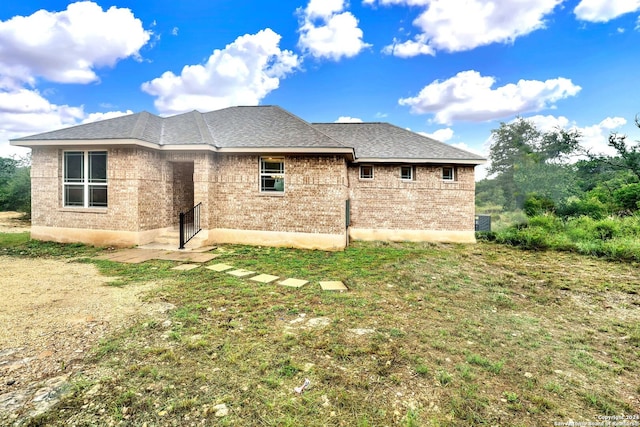 rear view of house featuring a yard