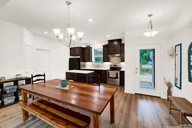 dining room featuring recessed lighting, light wood-style floors, baseboards, and a chandelier