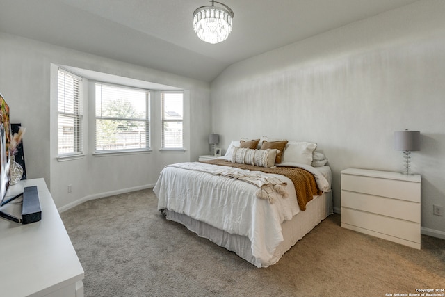 carpeted bedroom with lofted ceiling and an inviting chandelier