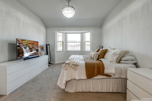 bedroom with lofted ceiling, light colored carpet, and an inviting chandelier