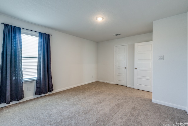 unfurnished room with light colored carpet