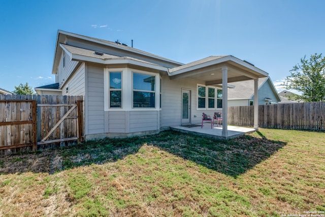 rear view of house featuring a patio area and a lawn