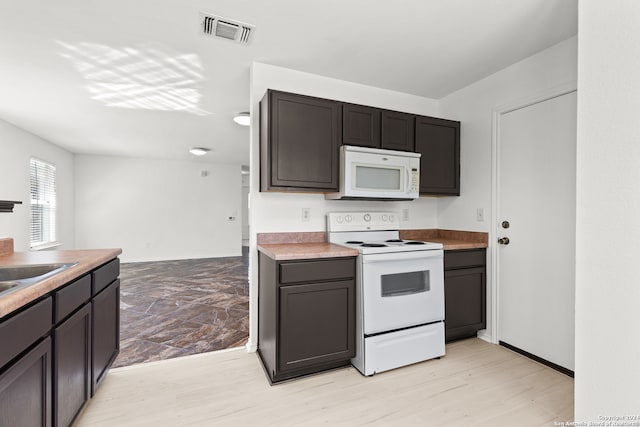 kitchen with white appliances and light hardwood / wood-style flooring