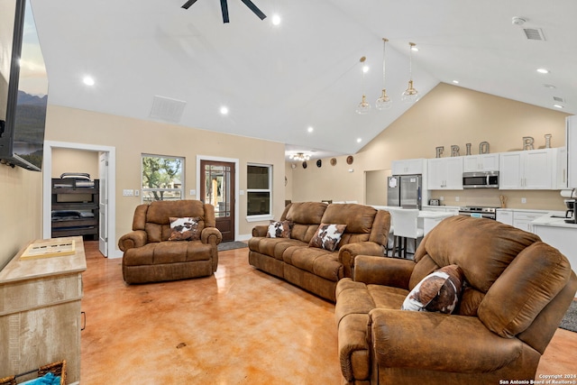 living room with ceiling fan with notable chandelier and high vaulted ceiling