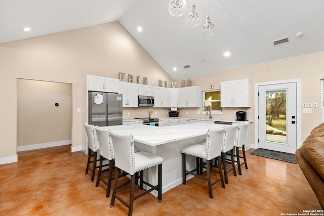 kitchen featuring stainless steel appliances, a kitchen island, sink, a breakfast bar area, and white cabinets