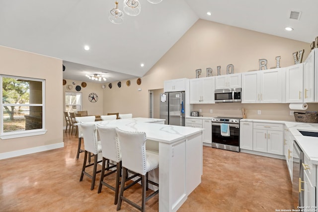 kitchen featuring a center island, stainless steel appliances, white cabinets, and a breakfast bar