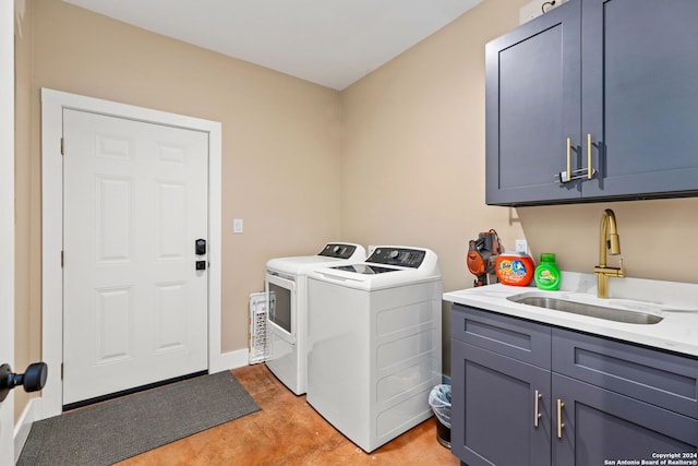 washroom with cabinets, washer and clothes dryer, and sink