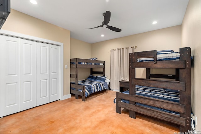 carpeted bedroom with ceiling fan and a closet