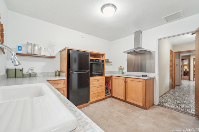 kitchen with sink, black appliances, and wall chimney exhaust hood