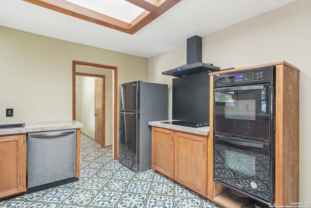 kitchen with a skylight, black appliances, and exhaust hood