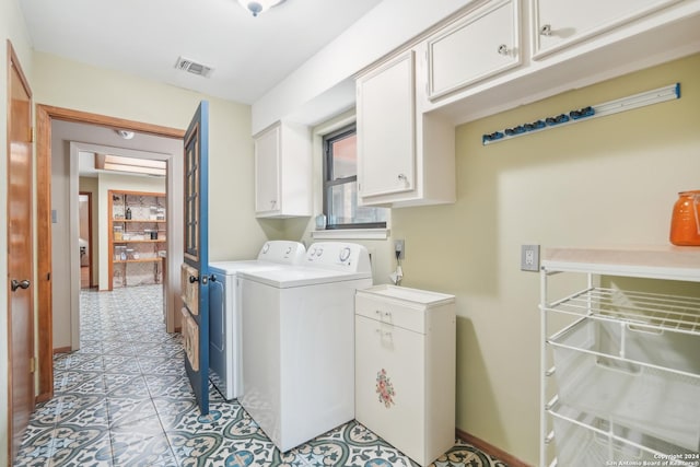 clothes washing area featuring separate washer and dryer and cabinets