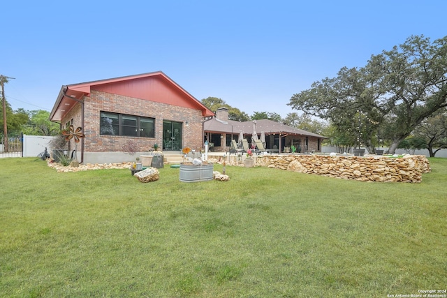 rear view of property featuring a lawn