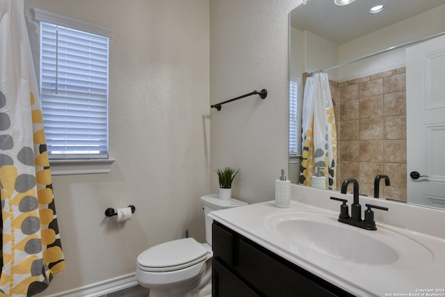 bathroom featuring a shower with curtain, toilet, a wealth of natural light, and vanity