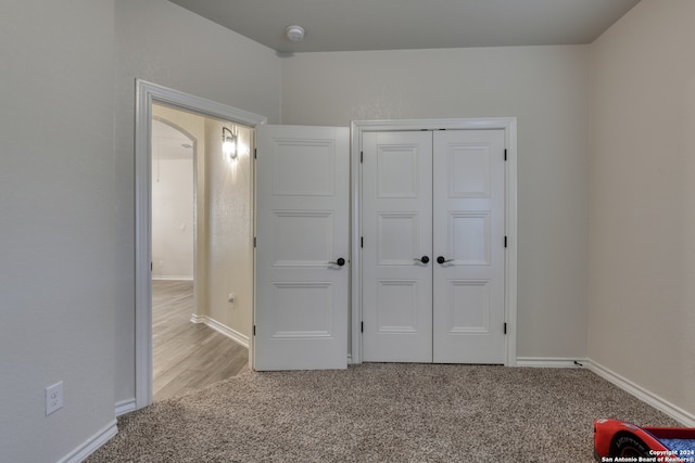 unfurnished bedroom featuring light colored carpet and a closet