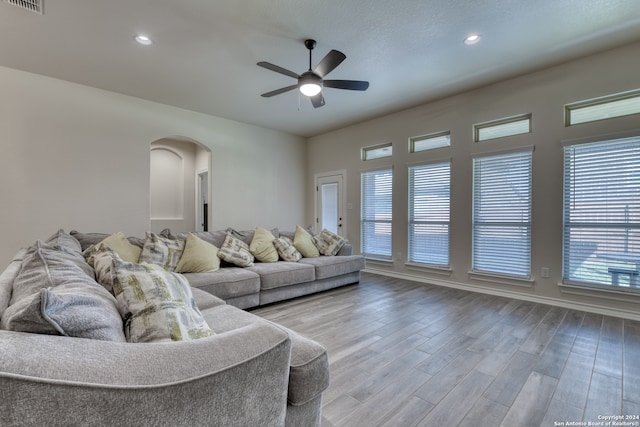 living room featuring ceiling fan, hardwood / wood-style flooring, and a healthy amount of sunlight