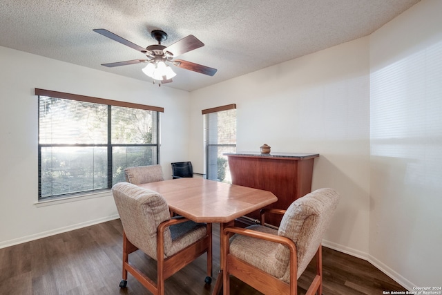 dining room featuring a textured ceiling, dark wood-type flooring, and ceiling fan