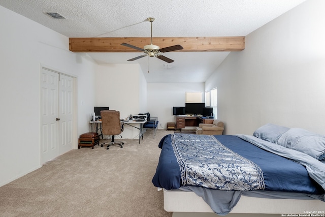 carpeted bedroom with a textured ceiling, ceiling fan, a closet, and vaulted ceiling with beams