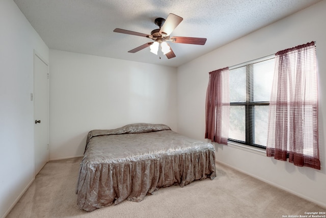 carpeted bedroom with a textured ceiling and ceiling fan