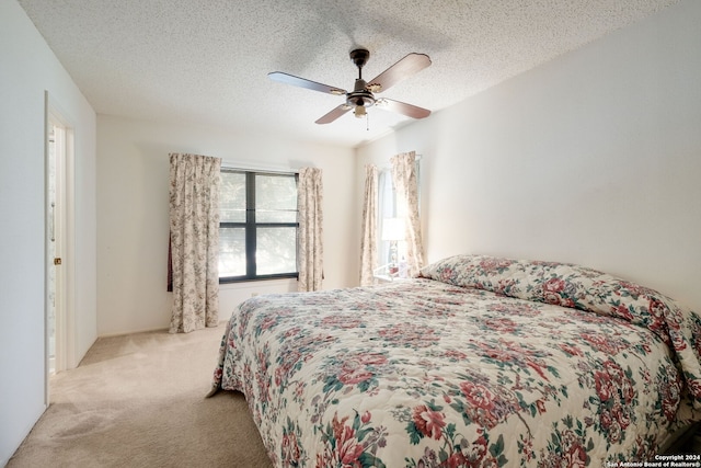 carpeted bedroom featuring a textured ceiling and ceiling fan