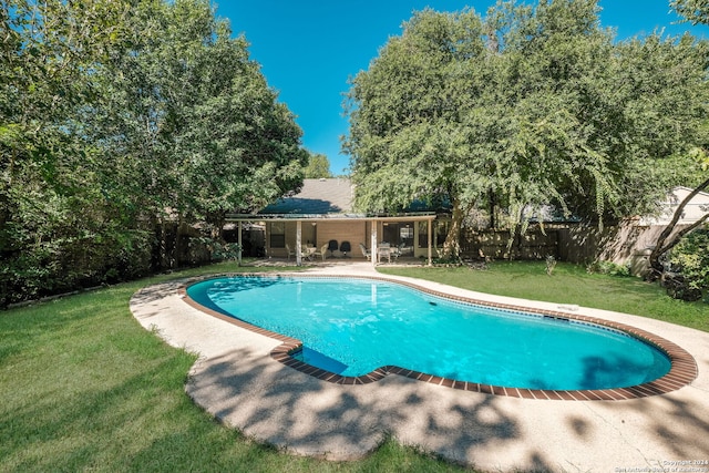 view of pool with a lawn and a patio