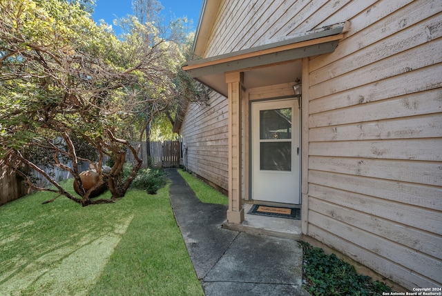 view of exterior entry with a yard