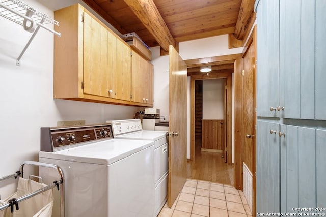 washroom with wooden walls, wooden ceiling, light hardwood / wood-style flooring, washing machine and clothes dryer, and cabinets