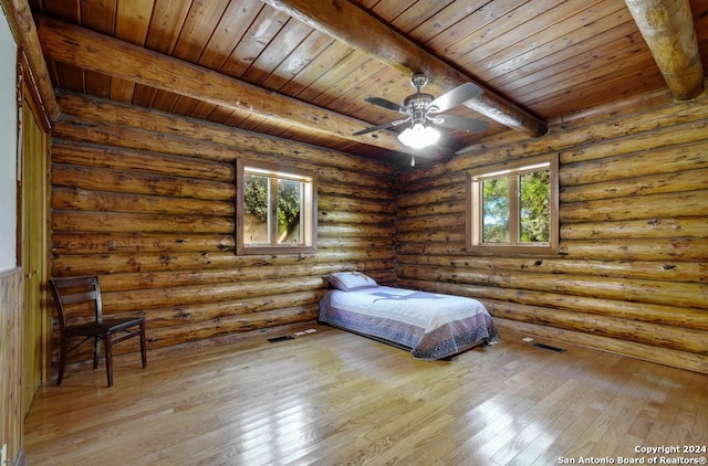 unfurnished bedroom with wood ceiling, light hardwood / wood-style flooring, beam ceiling, and rustic walls