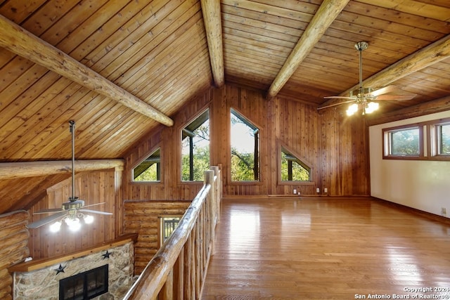 interior space with a wealth of natural light, beamed ceiling, and light hardwood / wood-style floors