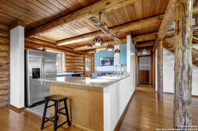 kitchen featuring log walls, light stone countertops, stainless steel appliances, light hardwood / wood-style floors, and kitchen peninsula