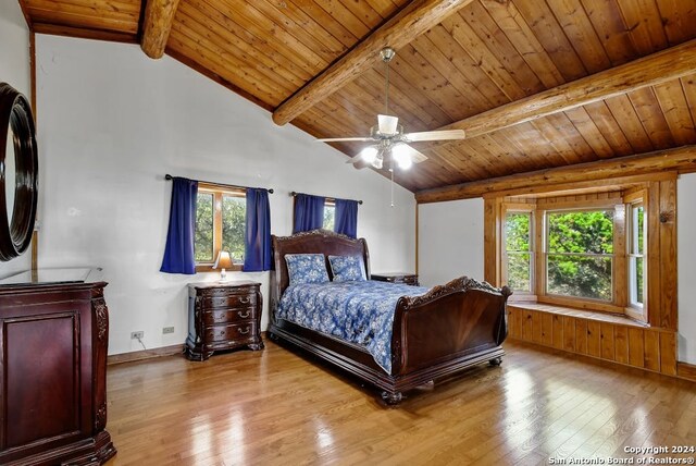 bedroom featuring lofted ceiling with beams, multiple windows, and light hardwood / wood-style flooring