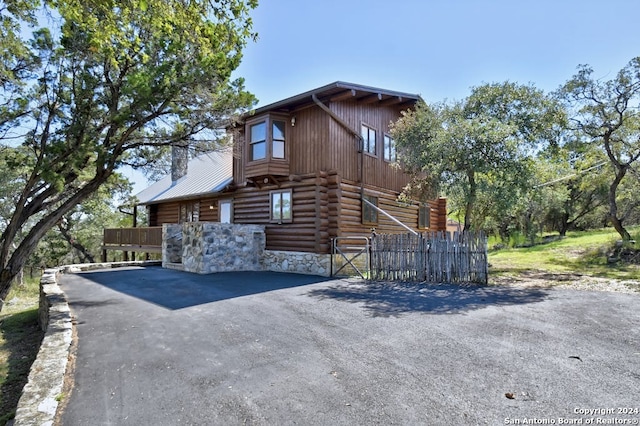 log home featuring log siding, a barn, an outdoor structure, and a chimney