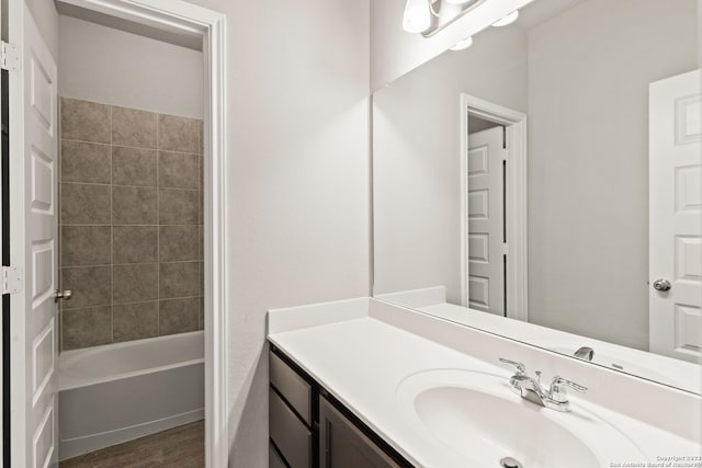 bathroom featuring hardwood / wood-style floors, vanity, and tiled shower / bath combo