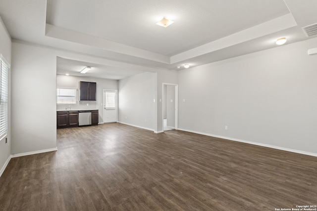 unfurnished living room with dark hardwood / wood-style flooring and a raised ceiling