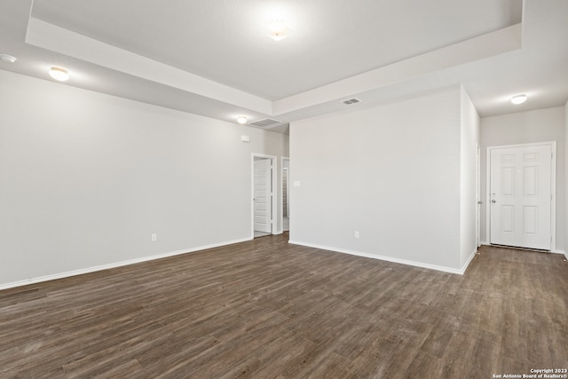 unfurnished room featuring dark hardwood / wood-style floors and a raised ceiling