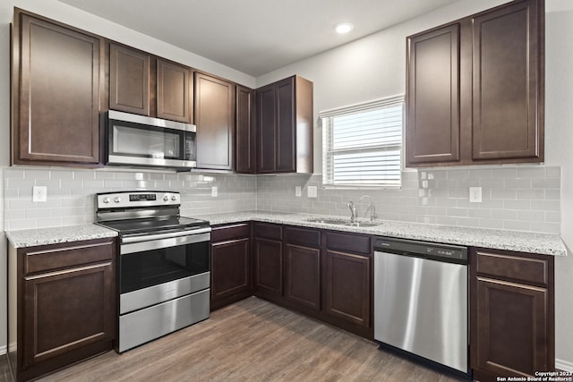 kitchen with dark hardwood / wood-style floors, dark brown cabinetry, sink, and appliances with stainless steel finishes