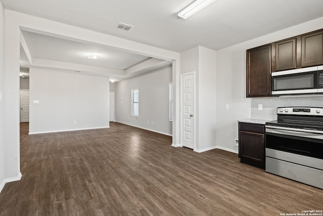 kitchen with tasteful backsplash, dark hardwood / wood-style flooring, stainless steel appliances, and dark brown cabinets