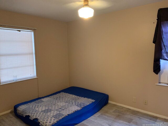 bedroom featuring multiple windows, ceiling fan, and light hardwood / wood-style floors