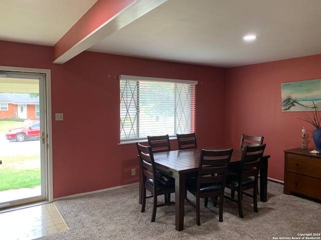 dining room featuring light colored carpet and a healthy amount of sunlight