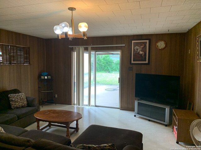 living room with wood walls and an inviting chandelier